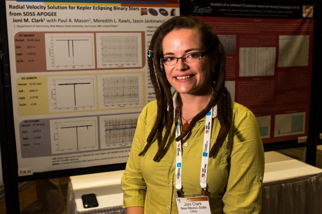 Joni Clark Cunningham poses in front of her poster at the American Astronomical Society meeting in Grapevine, Texas