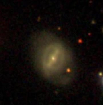 A faint galaxy with a bar and ring in the center and spiral arms coming out of the bar