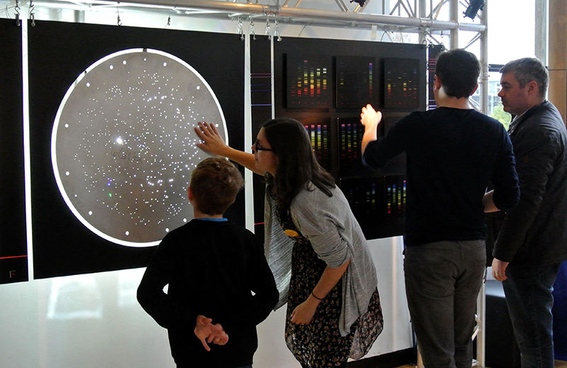 Museum visitors touch an SDSS plate as part of Tim Fitzpatrick's interactive exhibit